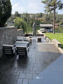 The same patio with the lounge furniture returned, looking out over the lawn and the lake.